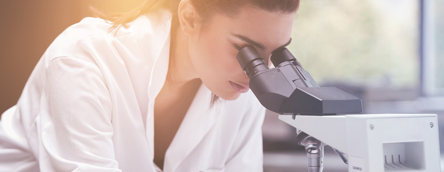 Chercheuse regardant dans un microscope